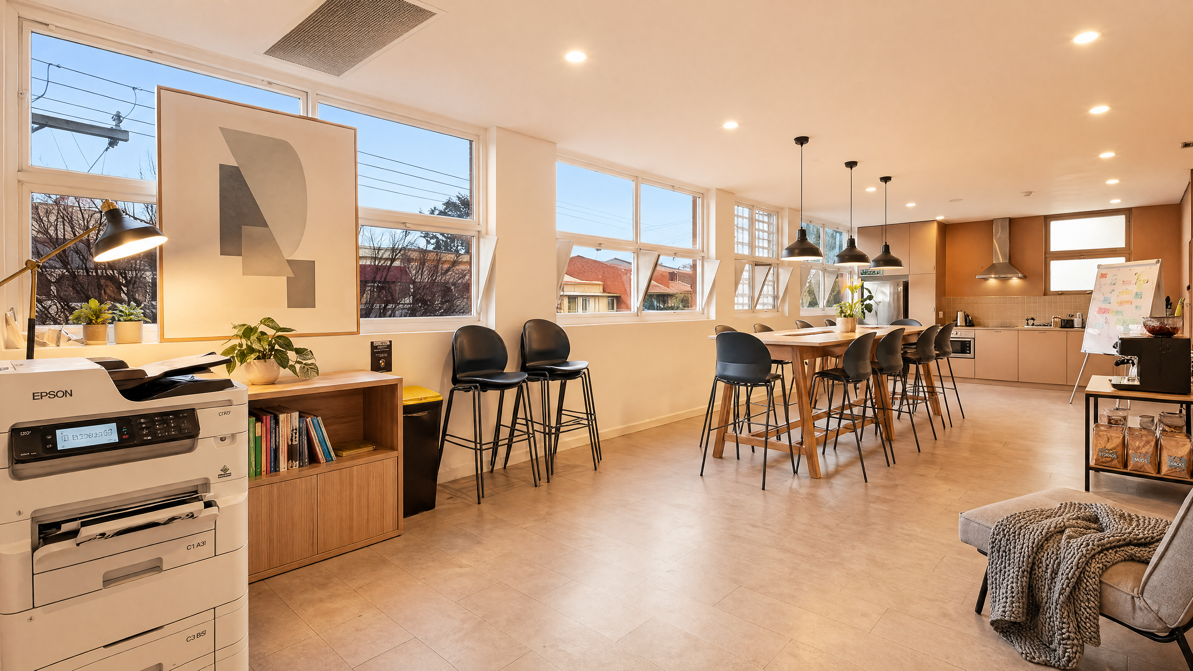 The kitchen — timber benchtop, bar stools, sash windows.