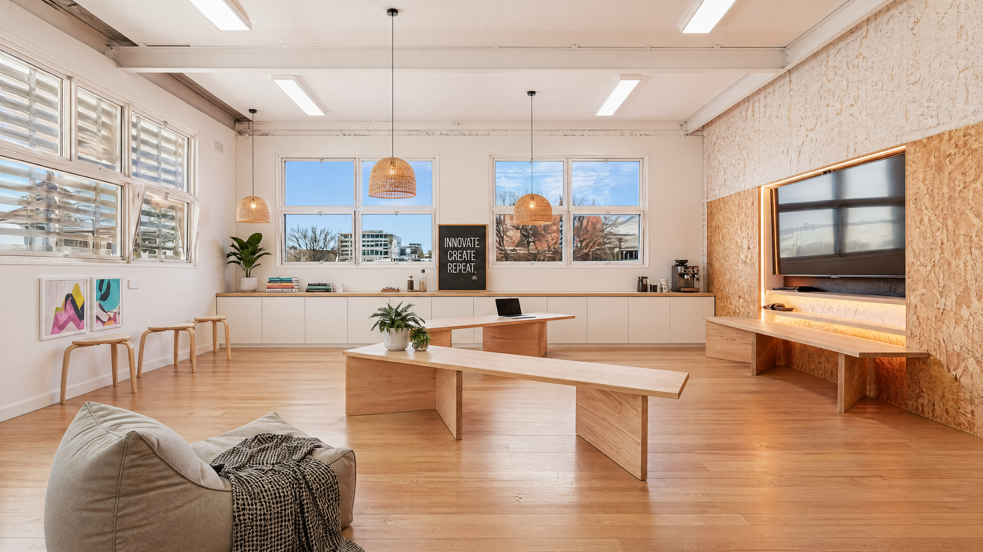 Breakout zone — long timber bench, sash windows, pendants.